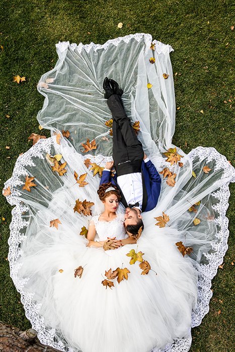 Беспилотная свадебная фотография пары, лежащей в траве