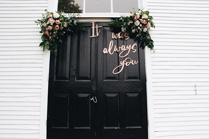 дверь, украшенная цветами и надписями как реквизит для свадебной фотографии
