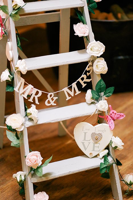 лестница, украшенная цветами и надписями, как реквизит для свадебной фотографии