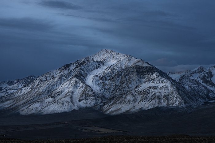 Снежная вершина горы с темным небом