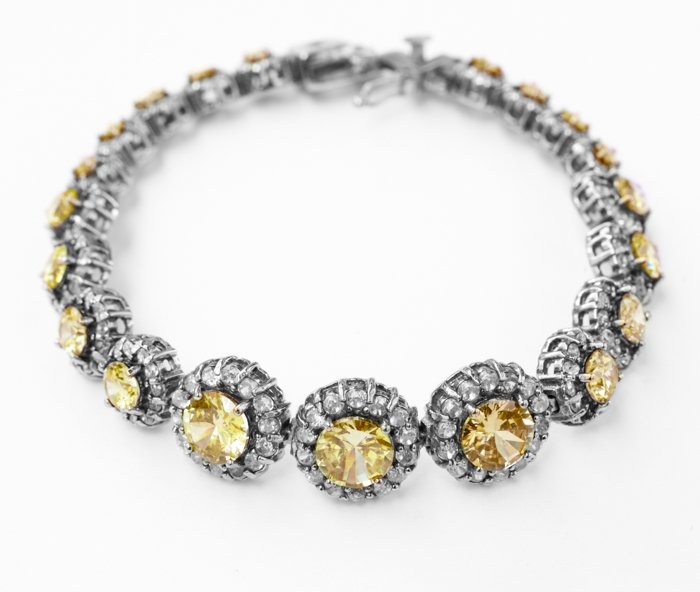 Ювелирная продукция фото серебряного ожерелья с белыми и желтыми камнями в нем на белом бэкграунде