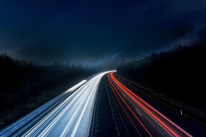 Оживленная ночная автострада со струящимися световыми дорожками