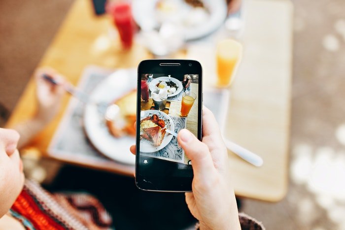 Человек фотографирует еду на iphone