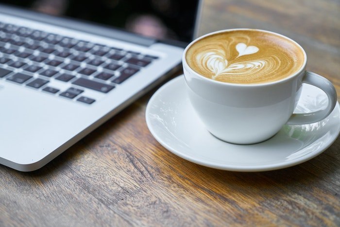 Чашка кофе рядом с ноутбуком