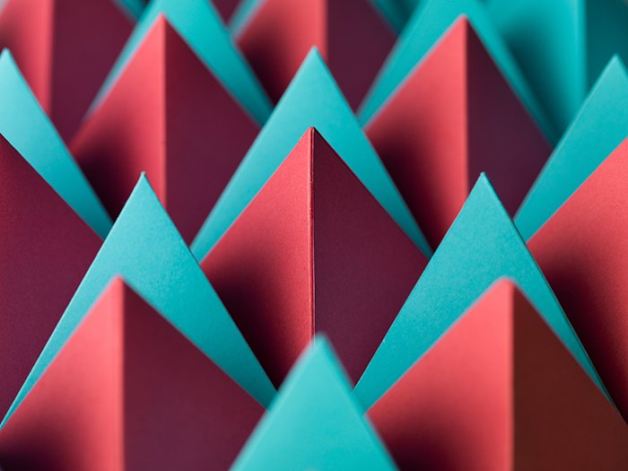 Абстрактная макросъемка с разноцветными пирамидками из бумаги.