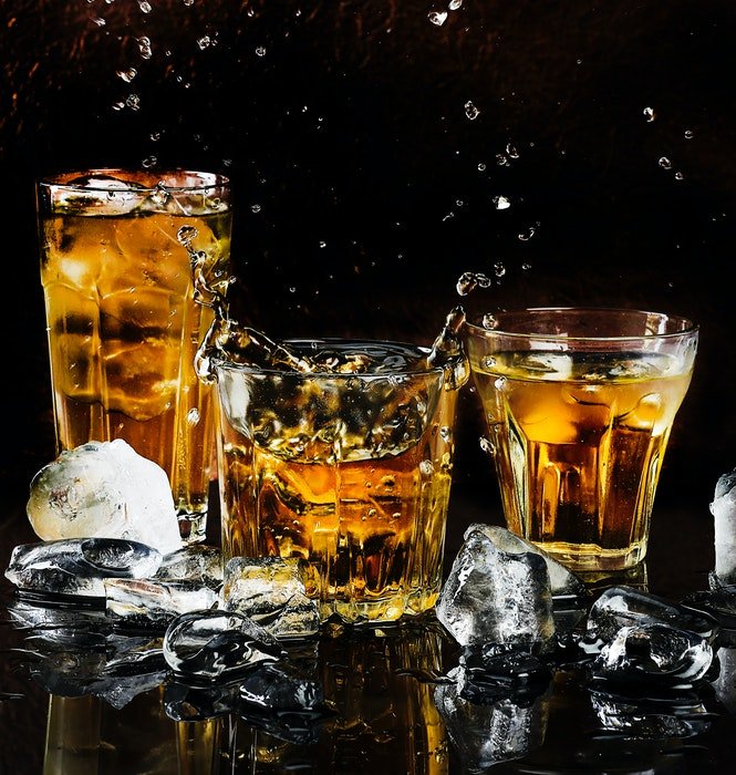 Три коктейля виски в окружении льда