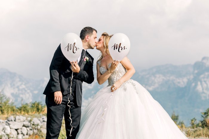 Милый свадебный портрет жениха и невесты, позирующих с воздушными шарами