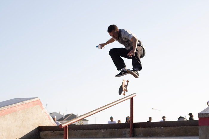 фото скейтбордиста в парке, выполняющего прыжковый трюк