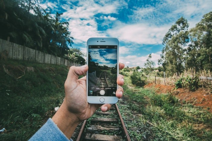Человек фотографирует смартфоном железнодорожные пути