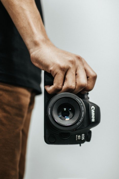 изображение крупным планом мужской руки, держащей Canon EOS 6D