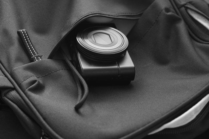 Компактная камера в рюкзаке. Черное и белое. Крупный план.