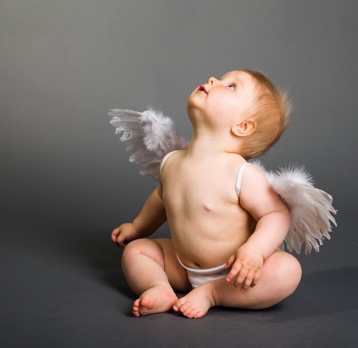 Сладкое рождественское фото малыша, одетого в ангельские крылья