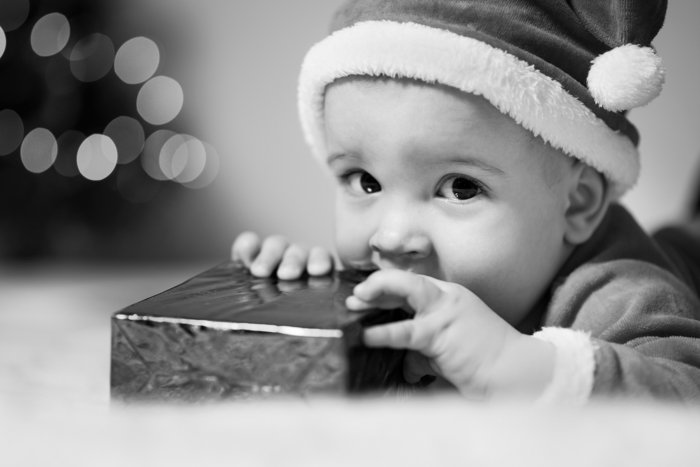 Черно-белый рождественский портрет мальчика с подарком