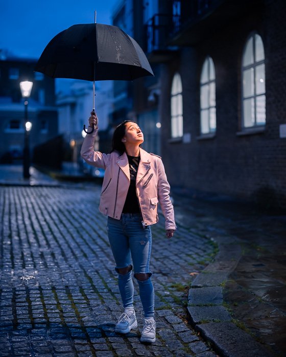 Портретный снимок девушки с зонтом, сделанный объективом Canon RF 50mm f/1.2L USM ночью