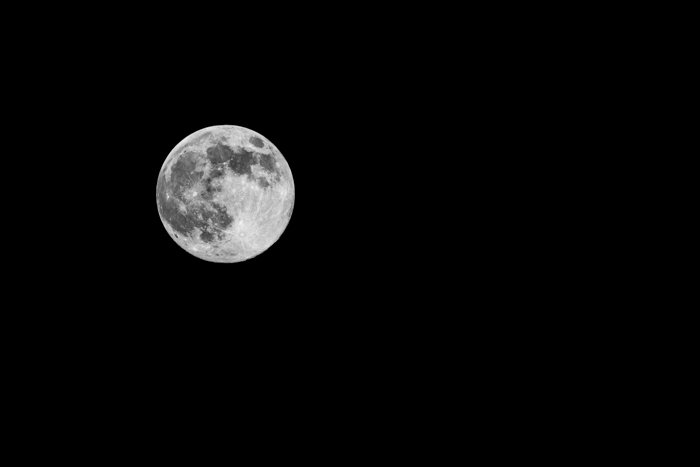 Полная луна с кратерами на фоне черного неба