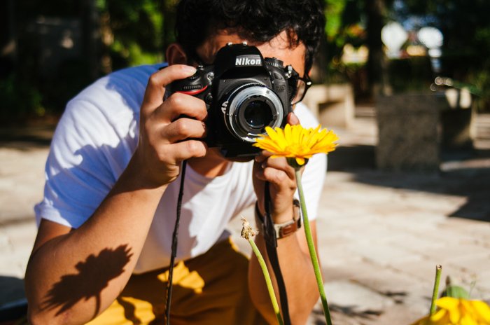 Мужчина фотографирует цветок