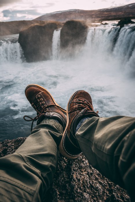 изображение ног мужчины крупным планом на фоне большого водопада
