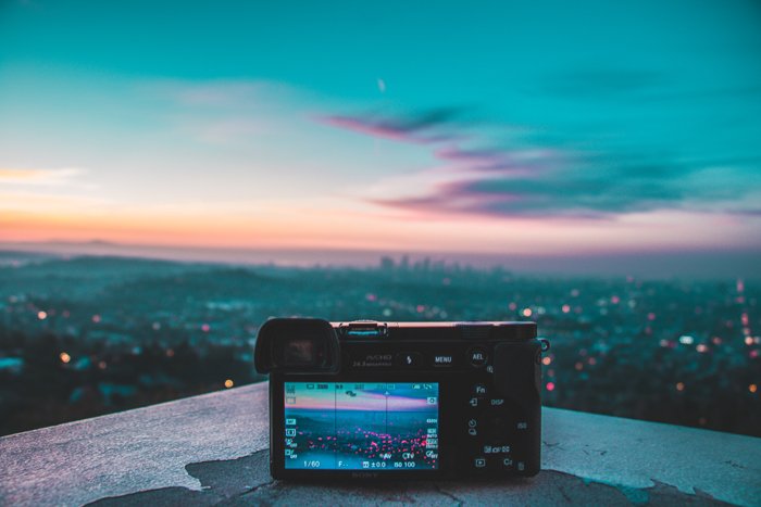 изображение беззеркальной камеры, установленной на карнизе с видом на городской пейзаж в сумерках