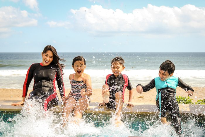 Семейные фотографии 4 детей, играющих в океане