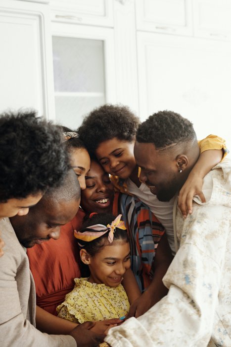 семейная фотография группы из семи человек, обнимающих друг друга