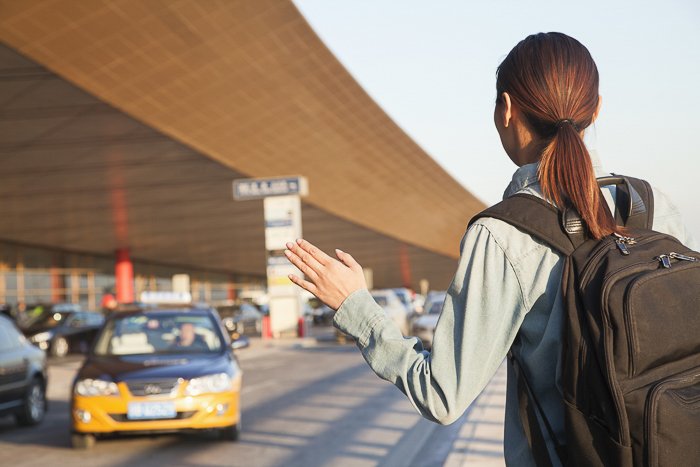изображение женщины, вызывающей такси в аэропорту
