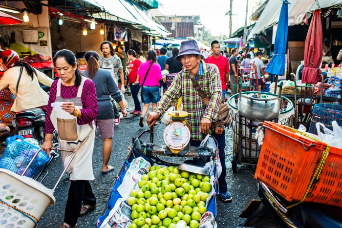 Экологический портрет мужчины, продающего яблоки на рыночной улице в Чиангмае