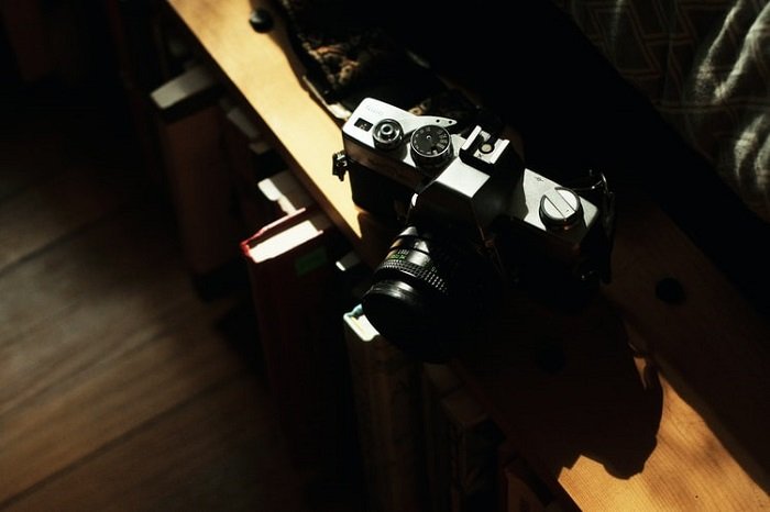 Темное изображение с зеркальной фотокамеры, размещенной на столе