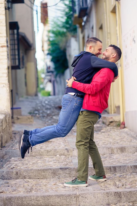 Фотография помолвки гей-пары в забавный и романтический момент на улице