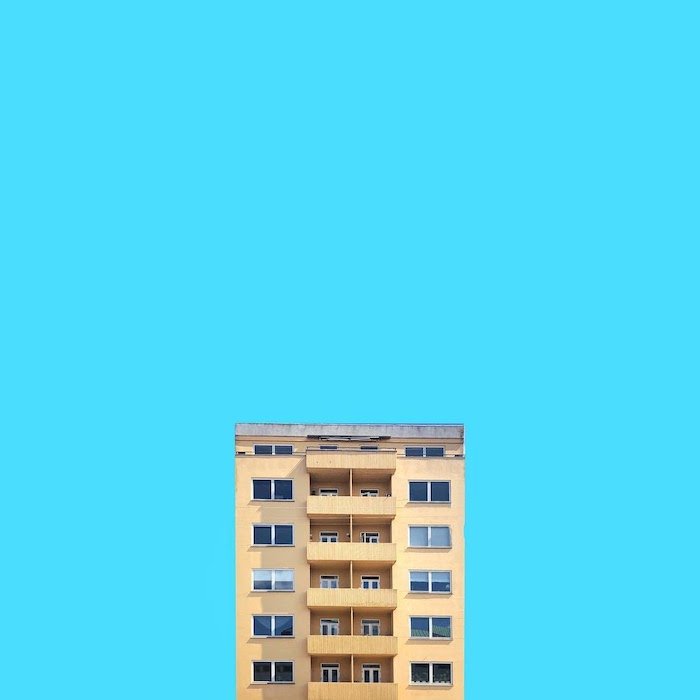 Минималистская архитектурная фотография симметричного здания на синем фоне