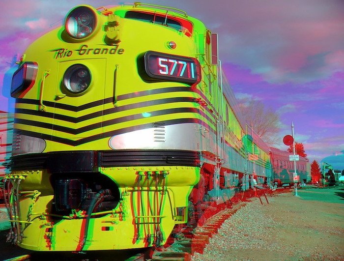 3D анаглифное фото передней части желтого поезда и его вагонов на рельсах