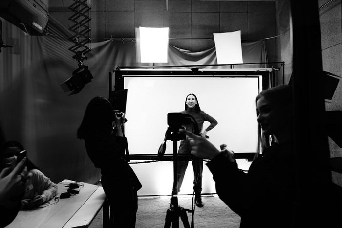 черно-белая фотография женщины-модели, позирующей в студии перед фотографом