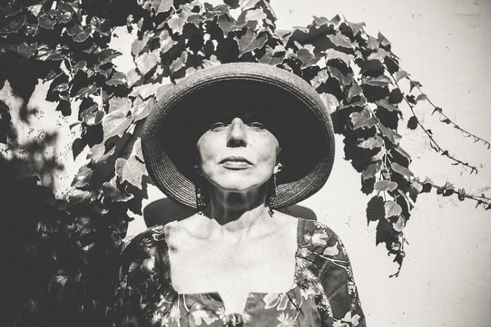 черно-белое киноизображение женщины в шляпе и цветочной блузке