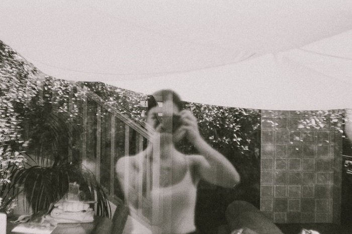 Черно-белая пленочная фотография вида из окна с отражением фотографа