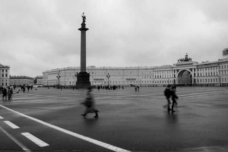 черно-белое киноизображение городской площади с размытыми пешеходами