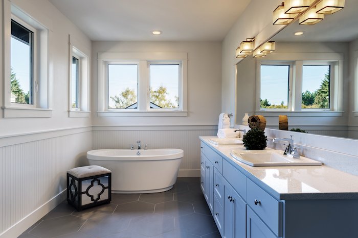 Ванная комната с ванной и раковинами, снятая для фотографии недвижимости