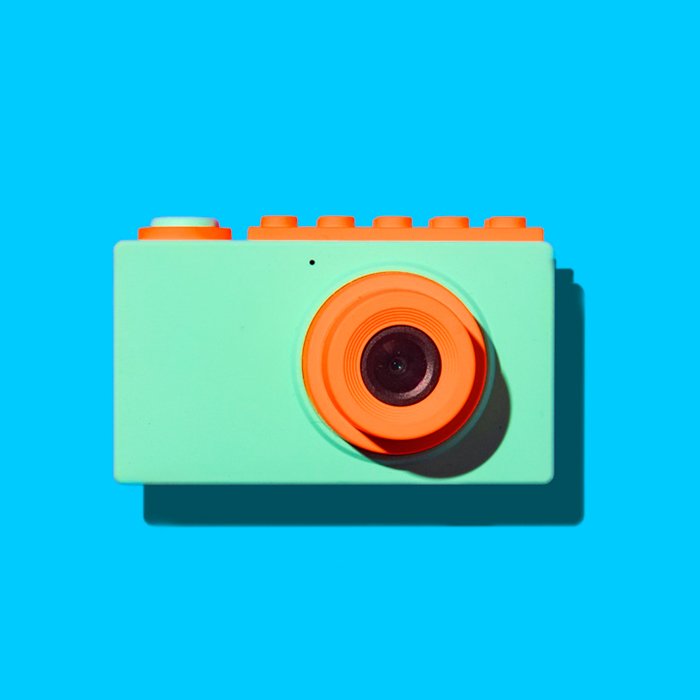 Оранжевая и зеленая камера на синем фоне