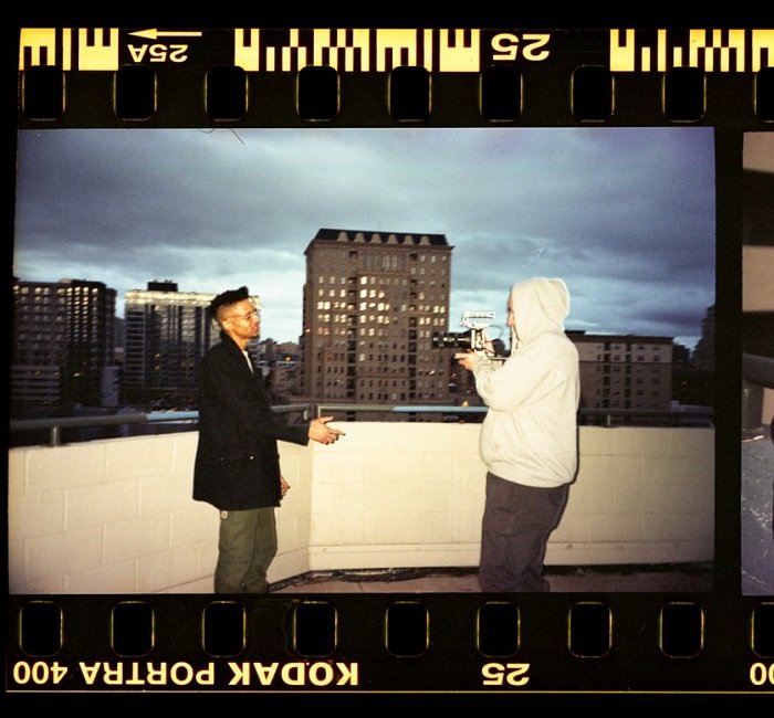 фильм фотографа, снимающего модель на фоне городского небоскреба