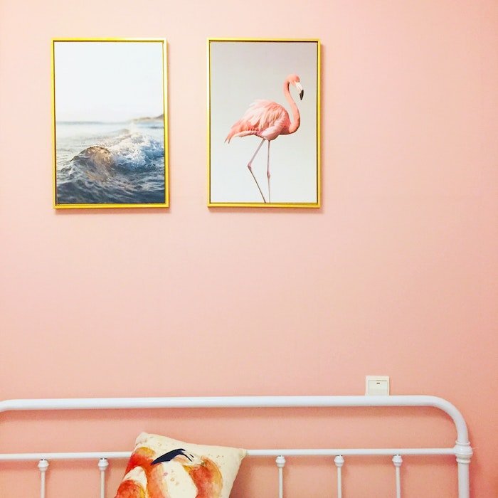 Увеличенные фотографии океана и фламинго в рамке над кроватью
