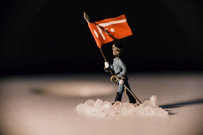 миниатюрная фотография солдата, несущего флаг по снегу