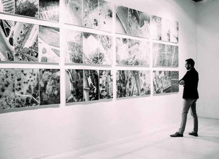 черно-белое изображение мужчины, просматривающего изображения в галерее