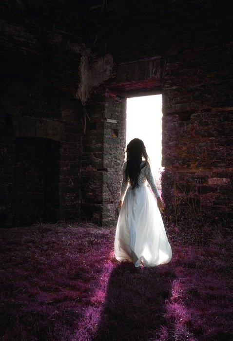 девушка, идущая к светлой каменной двери