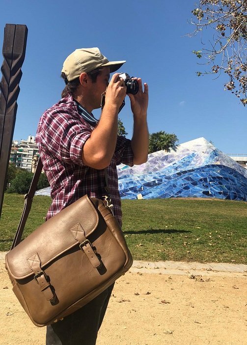 фотограф делает снимок в сумке Black Forest Messenger Camera Bag