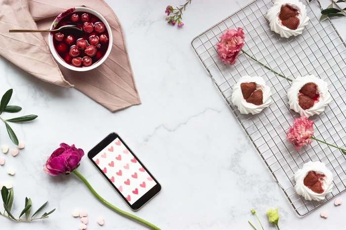 flat lay background idea: cherries, strawberries, and flowers on the marble countertop