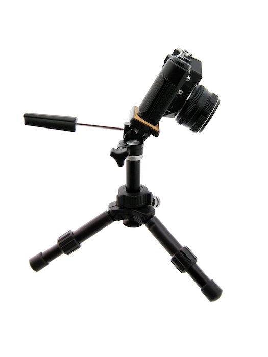 DSLR-камера, наклоненная вперед на штативе для плоской съемки товара