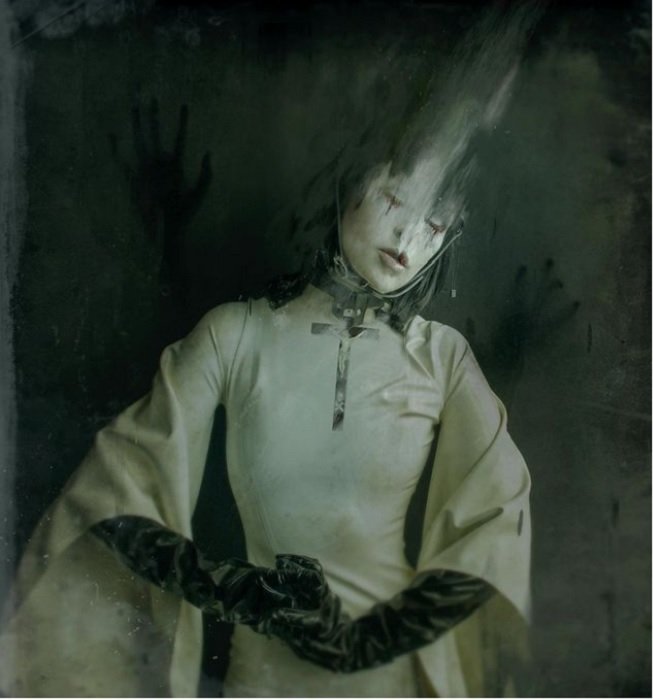 horror photography inspiration: a creepy woman with blurred hair dressed in white ceremonial garbles and black gloves