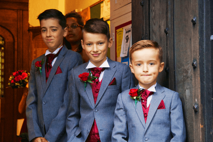 Идея свадебной съемки: Мальчики-пажи готовы принять гостей в церкви