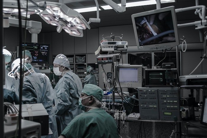 Медицинская фотография: Операционная с медицинским персоналом и хирургами в зеленых халатах и масках