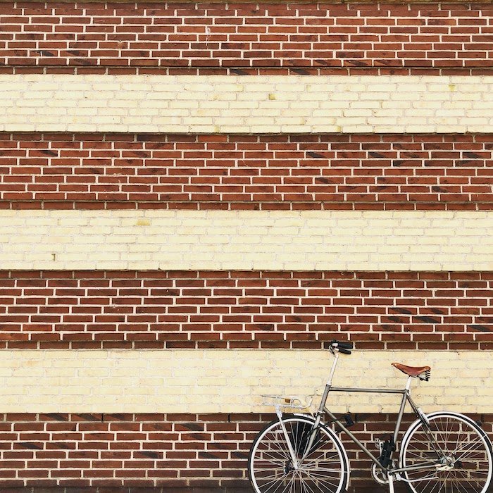 Повторение в фотографии: Велосипед, прислоненный к стене с повторением кирпичных узоров