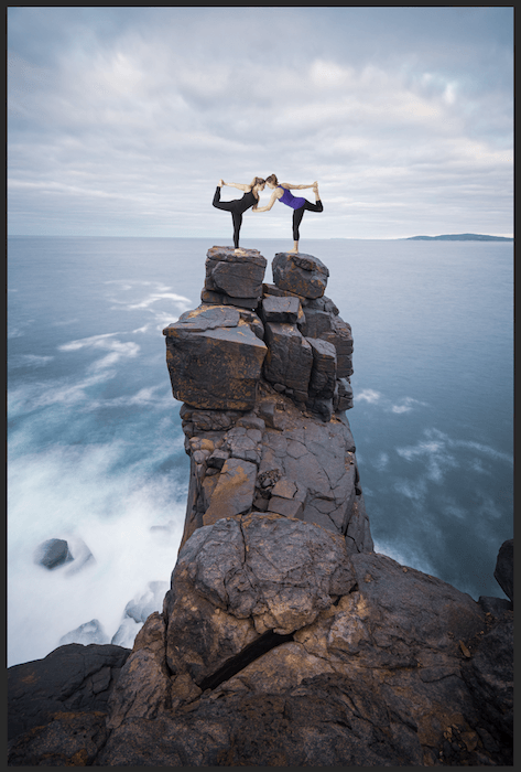 Вырезанное изображение женщины в позе йоги на вершине скалы в Photoshop для композитной фотографии