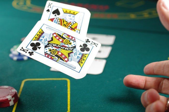 Сфотографировано движение: Пара игральных карт короля бросается на стол для покера